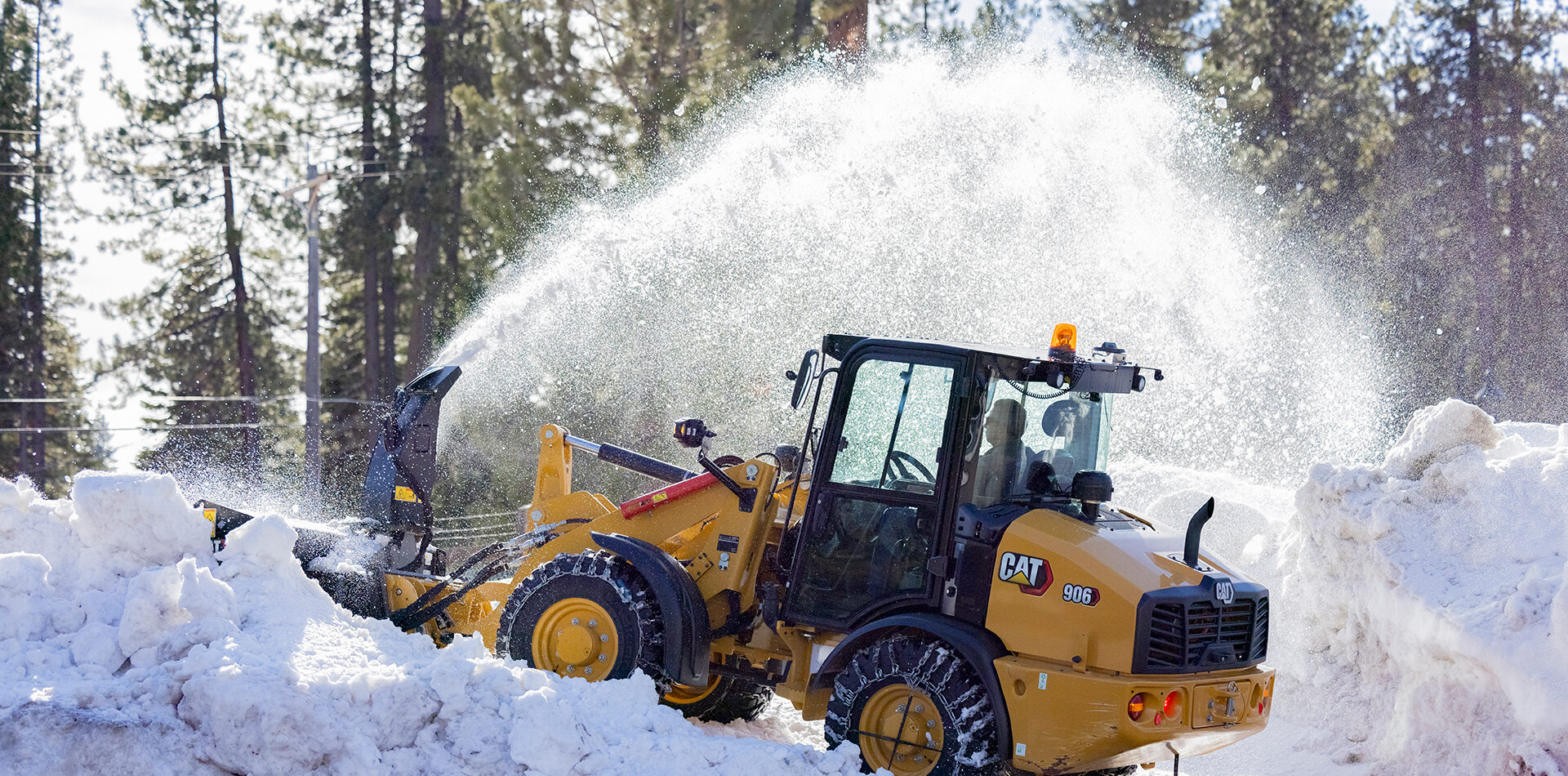 Cat 906 snöröjer så att snön yr