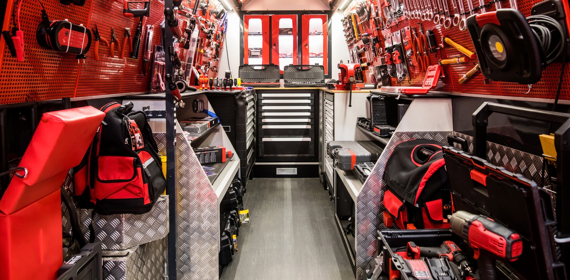 Image of a mobile auto service truck with various tools and devices inside.